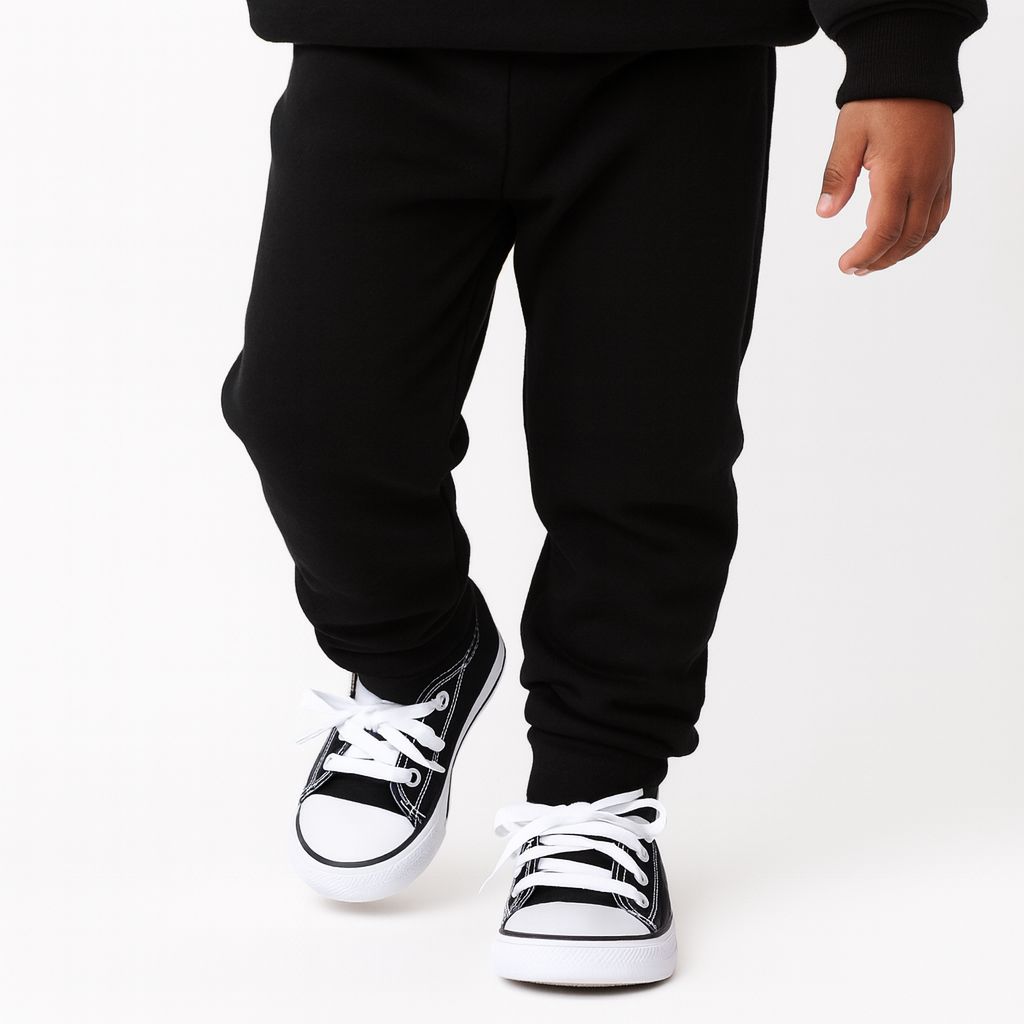 toddler wearing black sponge fleece jogger sweatpants walking forward neutral studio background