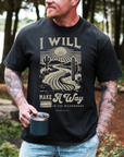Man wearing a black t-shirt with a desert graphic and text, holding a mug outdoors.