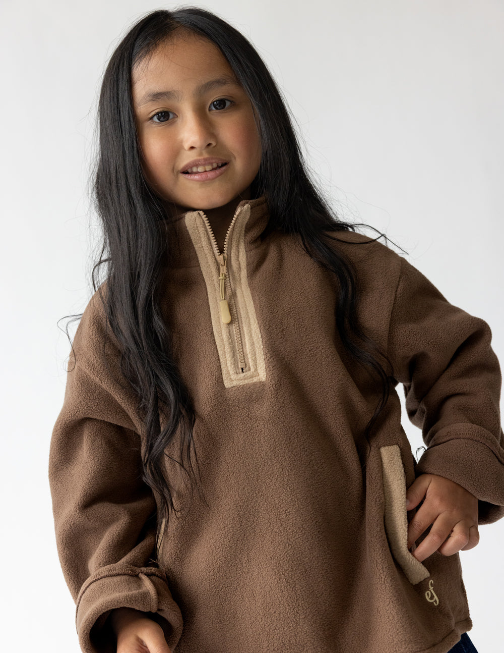 Child wearing a Chestnut fleece quarter-zip pullover with cream zipper details.