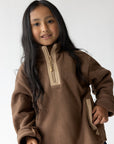 Child wearing a Chestnut fleece quarter-zip pullover with cream zipper details.