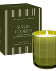 Sweet Water Decor Sugar Cookies 12 oz candle in an olive glass jar beside its patterned gift box.