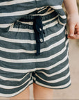 Child wearing a striped outfit with a blurred background