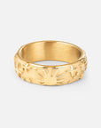 Gold-tone Celestial Ring with raised celestial motifs around a wide band on a light background