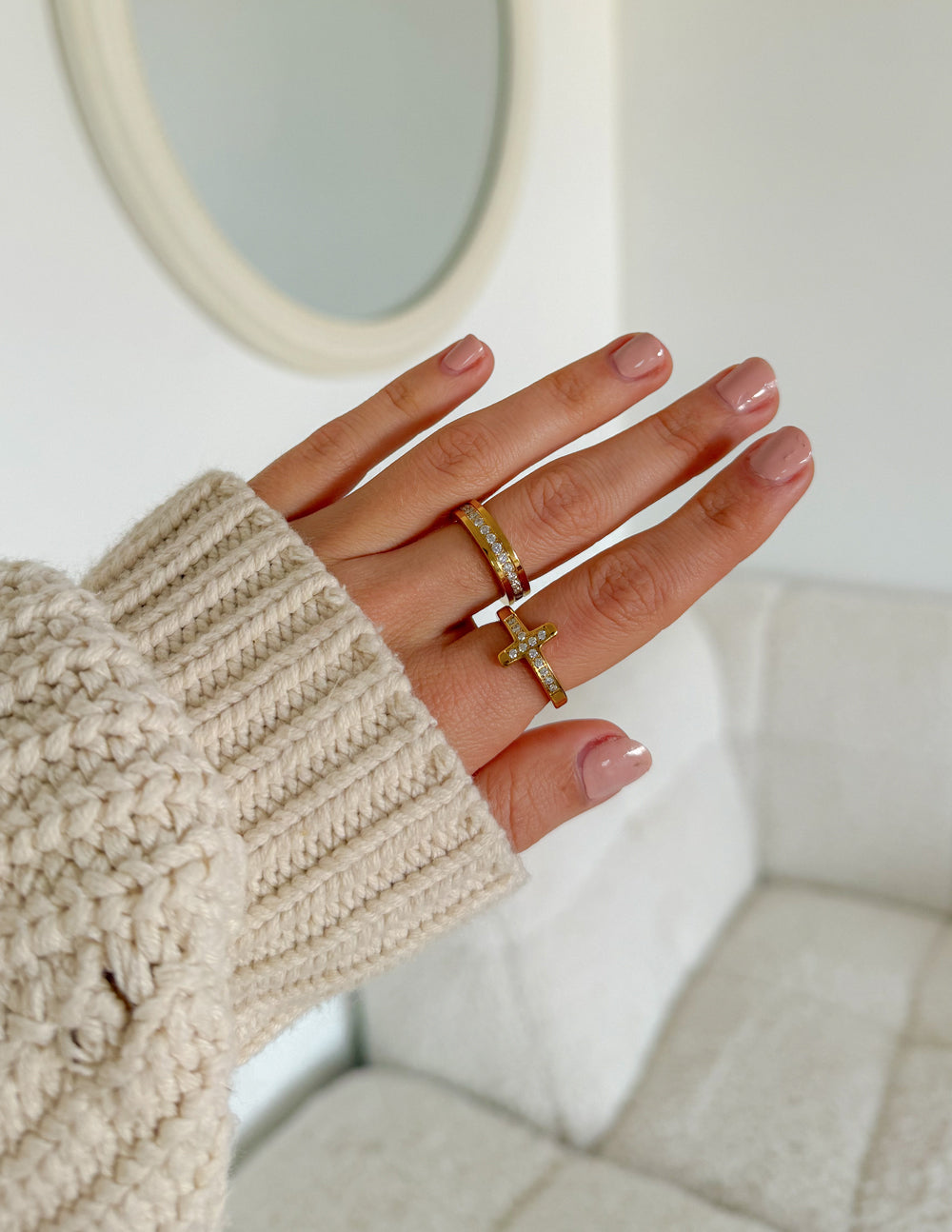Gold-tone cross ring and matching band styled with a cream sweater