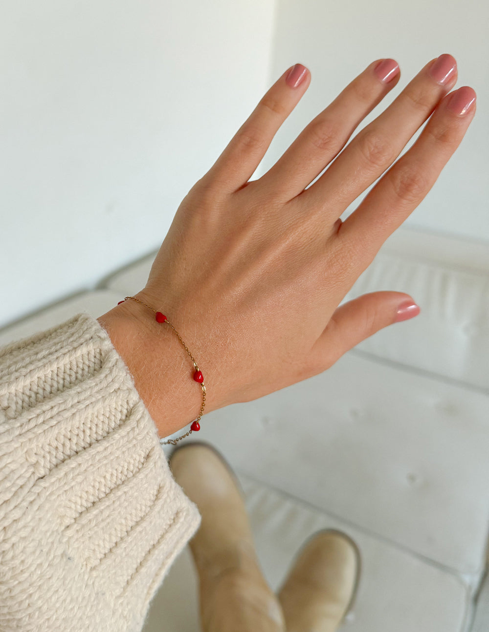 Dainty Love Link Bracelet worn on a wrist, showing delicate red hearts