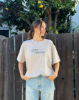 Front view of the Chateau Grey Disciples Heavyweight Tee styled with blue jeans outdoors