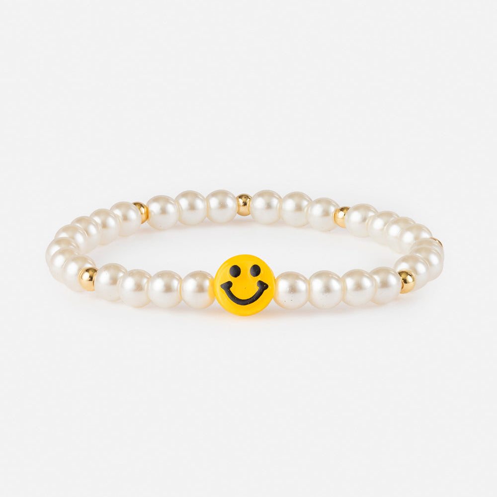 Pearl bracelet with a yellow smiley face charm on a white background
