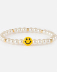 Pearl bracelet with a yellow smiley face charm on a white background