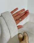 Enamel North Star ring worn on a hand with a light knit sweater sleeve indoors
