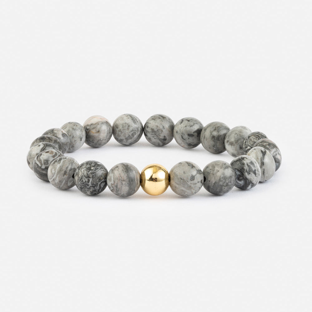 Gray beaded bracelet with a gold accent on a white background