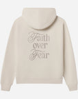 Beige hoodie with 'Faith over Fear' text on the back against a white background