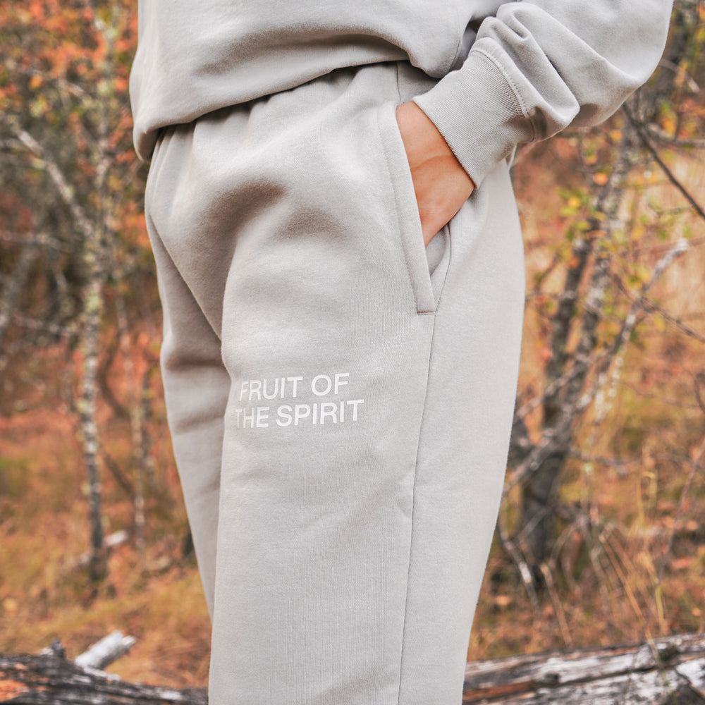 Gray sweatpants with 'Fruit of the Spirit' text in an autumn forest setting