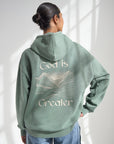 Angled back view of the God Is Greater Hoodie showing the light-colored embroidered mountain design.
