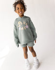Front view of a child wearing Millstone Grey God Made Me shorts and a coordinating hoodie