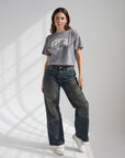 God of Miracles cropped tee layered beneath a tan cardigan
