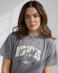 Woman wearing a gray t-shirt with text on a plain background