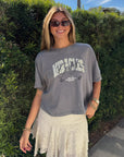 Model wearing God of Miracles cropped tee with a cream skirt