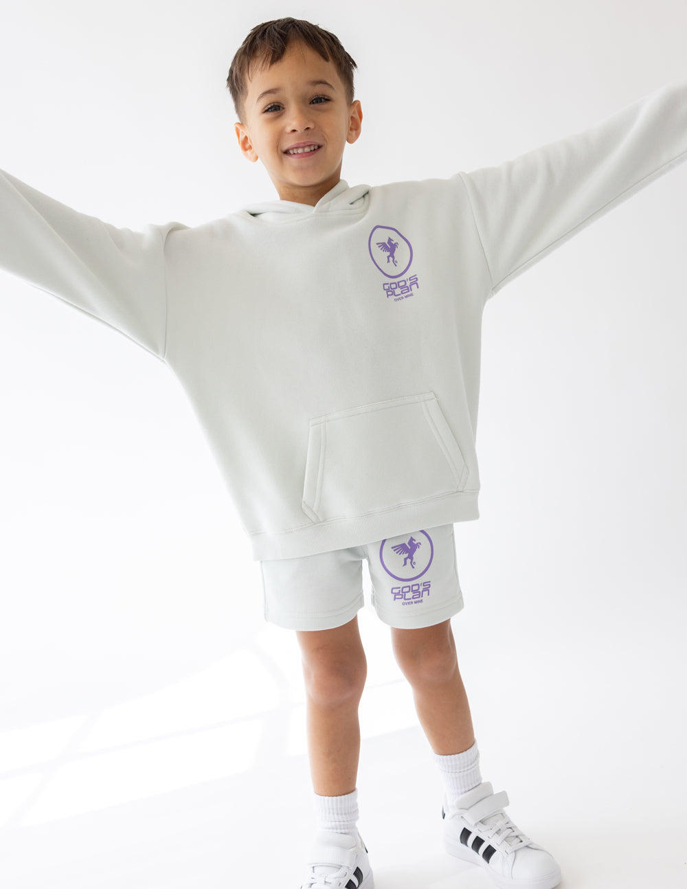 Child wearing the Icicle God’s Plan Racing hoodie with arms extended and coordinating shorts.
