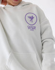 Close-up of the hoodie’s purple chest graphic and front pouch pocket.