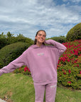 Woman wearing the God’s Promises Hoodie and coordinating pants with her arms extended outdoors.