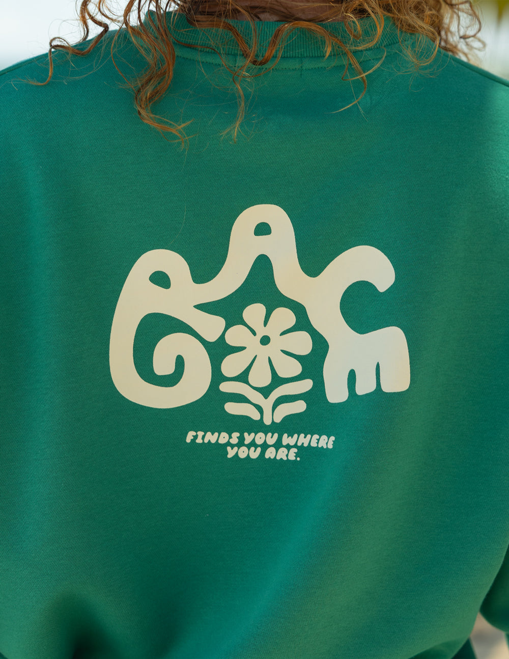 Close-up of cream Grace lettering and the floral accent on the back of a green crewneck sweatshirt