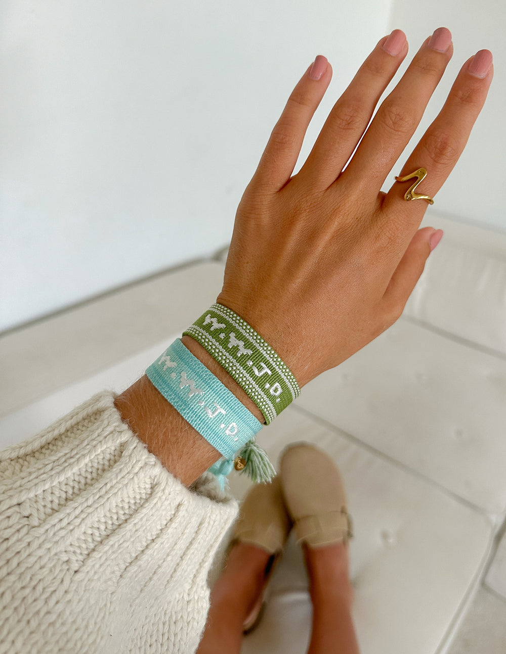 Jade green WWJD bracelet stacked with a turquoise woven bracelet on a wrist
