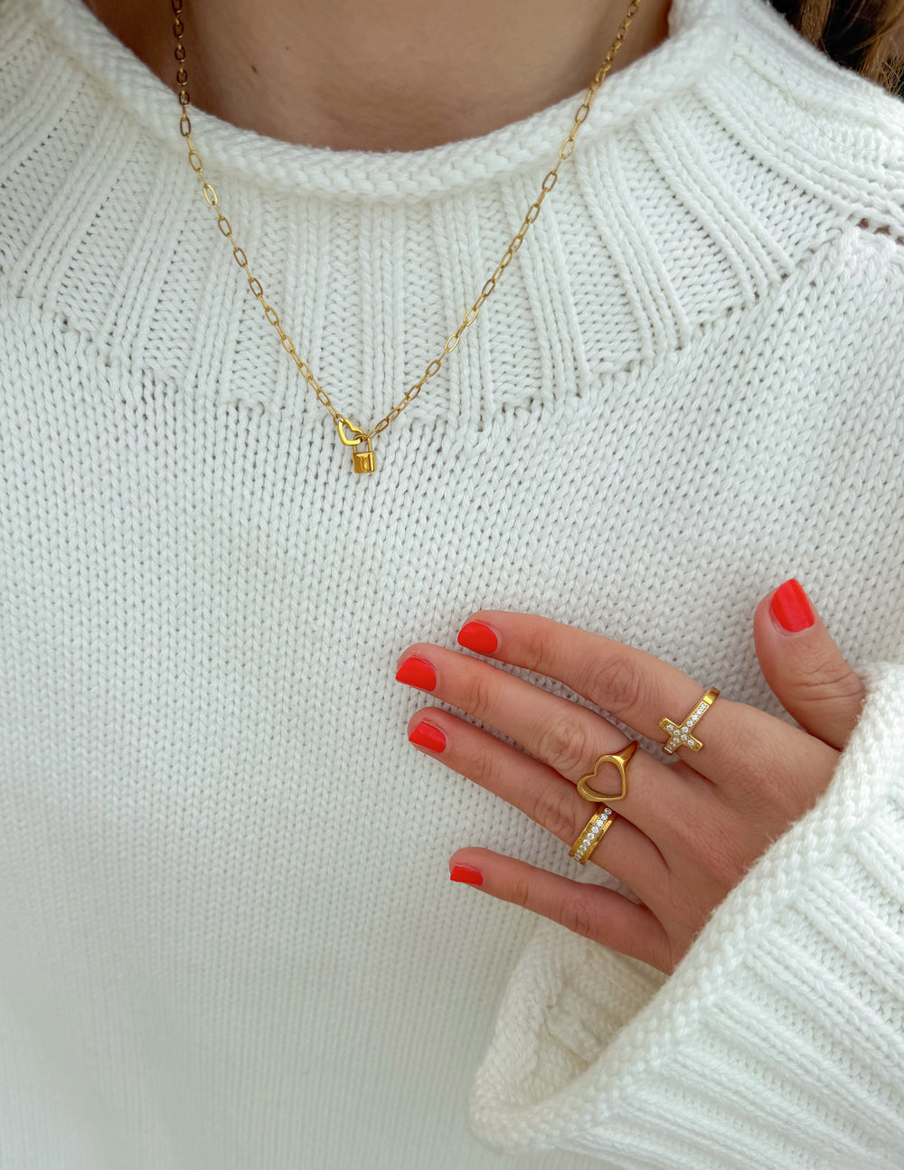 Heart Lock Paperclip Chain Necklace styled with a white sweater and gold-tone rings.