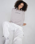 Seated model wearing the Gray Daze hoodie with small His Kingdom Come chest lettering