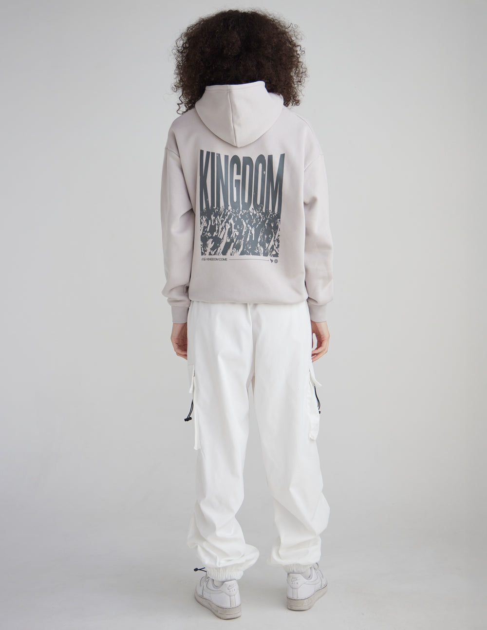 Back view of a model wearing the His Kingdom Come Gray Daze Hoodie with white pants