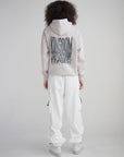 Back view of a model wearing the His Kingdom Come Gray Daze Hoodie with white pants