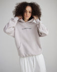 Front view of a model holding the hood of the His Kingdom Come Gray Daze Hoodie