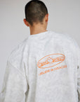 Close-up of the orange back graphic on the I Believe in Miracles White Camo tee