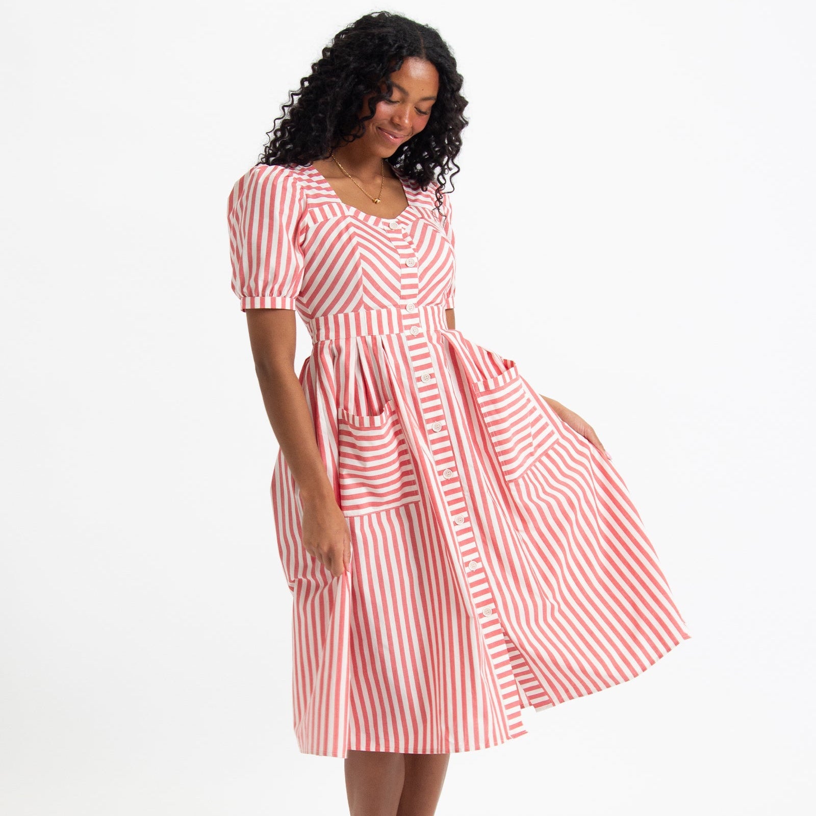 Woman wearing a red and white striped dress on a white background