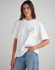 Front view of a woman wearing the White Sand heavyweight T-shirt with jeans