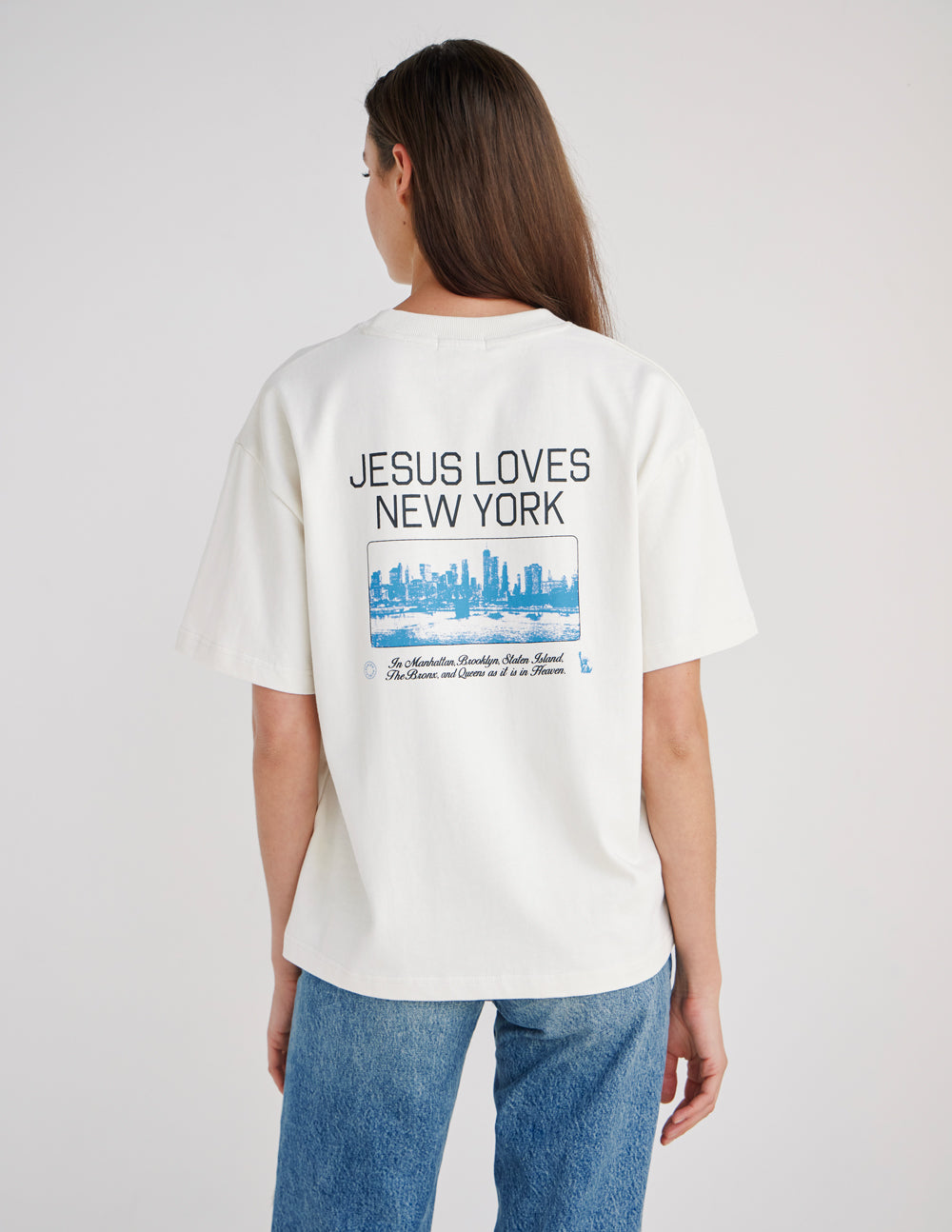 Back view of the Jesus Loves New York Early Frost tee with bold lettering and a blue city skyline graphic.