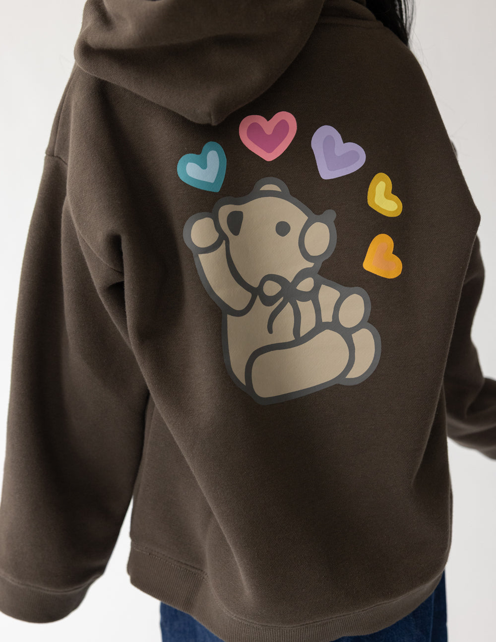 Close-up of the teddy bear and colorful heart graphics on the Coffee Jesus Loves You Kids Hoodie