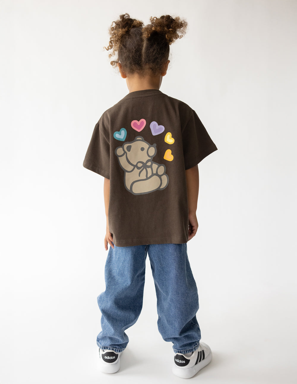 Back of Jesus Loves You Coffee Kids Tee with a teddy bear and colorful hearts, worn with jeans