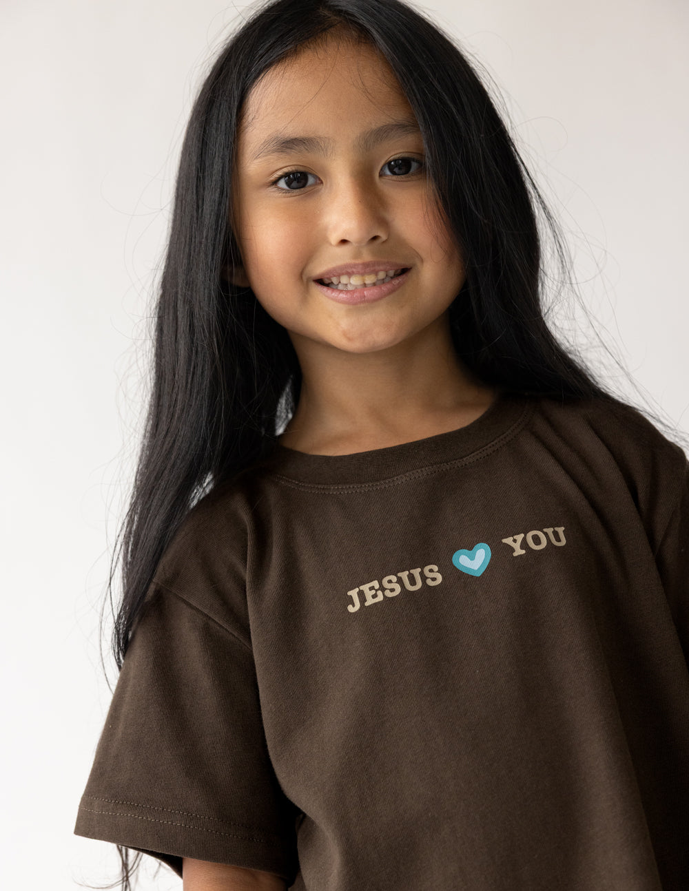 Front detail of Coffee kids tee with Jesus Loves You lettering and a small blue heart
