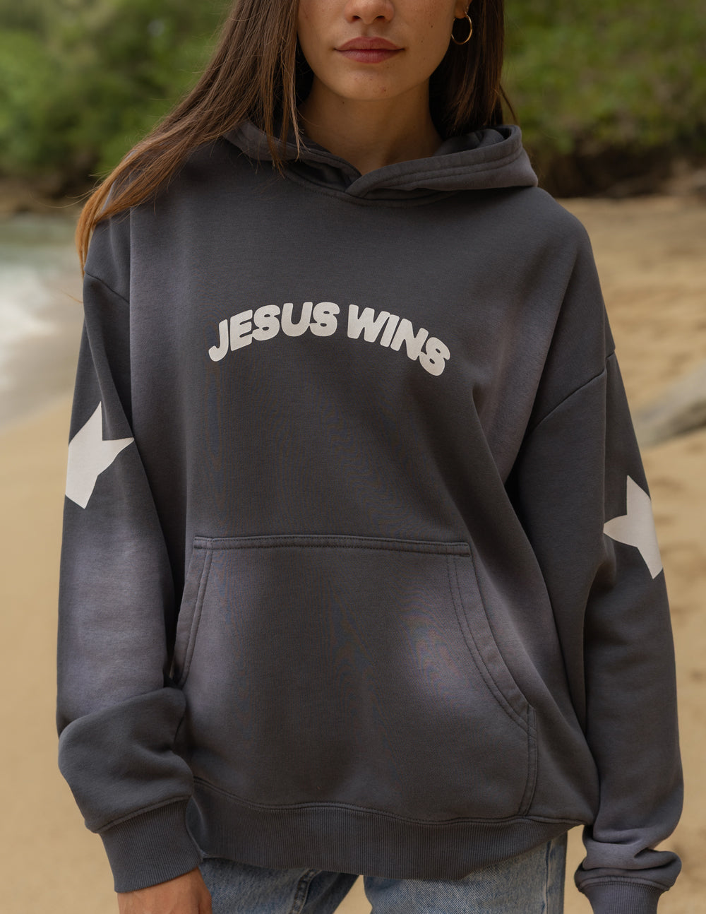 Front view of the Black Tide Jesus Wins Hoodie showing chest lettering, sleeve stars, and a kangaroo pocket