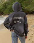 Model wearing the Black Tide Jesus Wins Hoodie with the hood up and back message visible outdoors