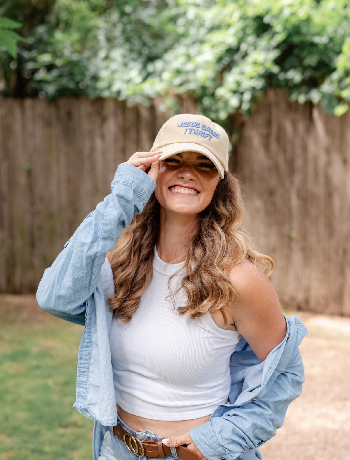 Model outdoors wearing the Jesus Saves I Thrift Sand Embroidered Hat with a white top and denim jacket
