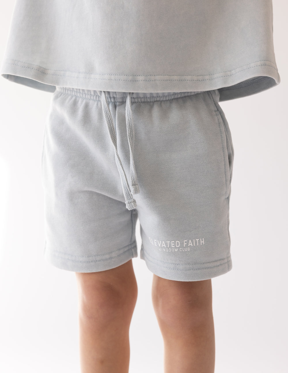 Front view of the Kingdom Club kids’ shorts showing side pockets and subtle white lettering near the hem.