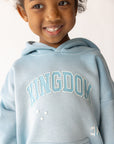 Close-up of the Air Blue Kingdom Kids Hoodie showing puff-print Kingdom lettering