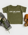 Green t-shirt with 'Love Like Jesus' text, gray pants, and brown shoes on a white background