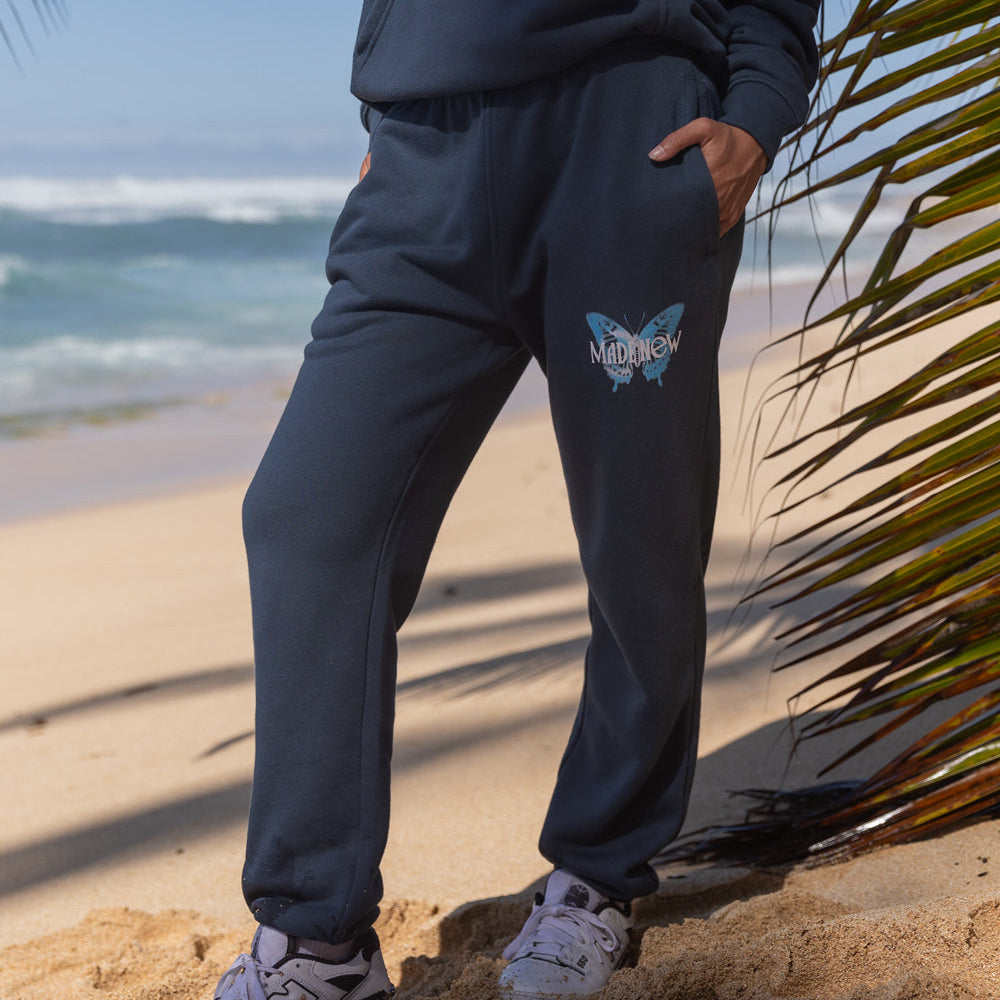 Person wearing dark blue tracksuit with a logo on a beach