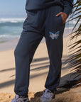 Person wearing dark blue tracksuit with a logo on a beach