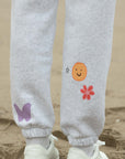 Gray sweatpants with colorful designs on a sandy background