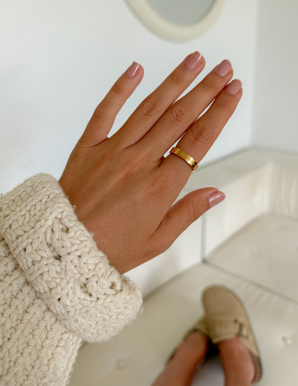 Made by Believers gold-tone band ring worn on a hand with a cream knit sleeve