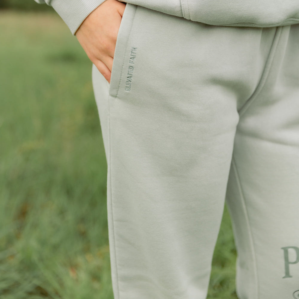 Light gray sweatshirt and pants worn by a person in a grassy field