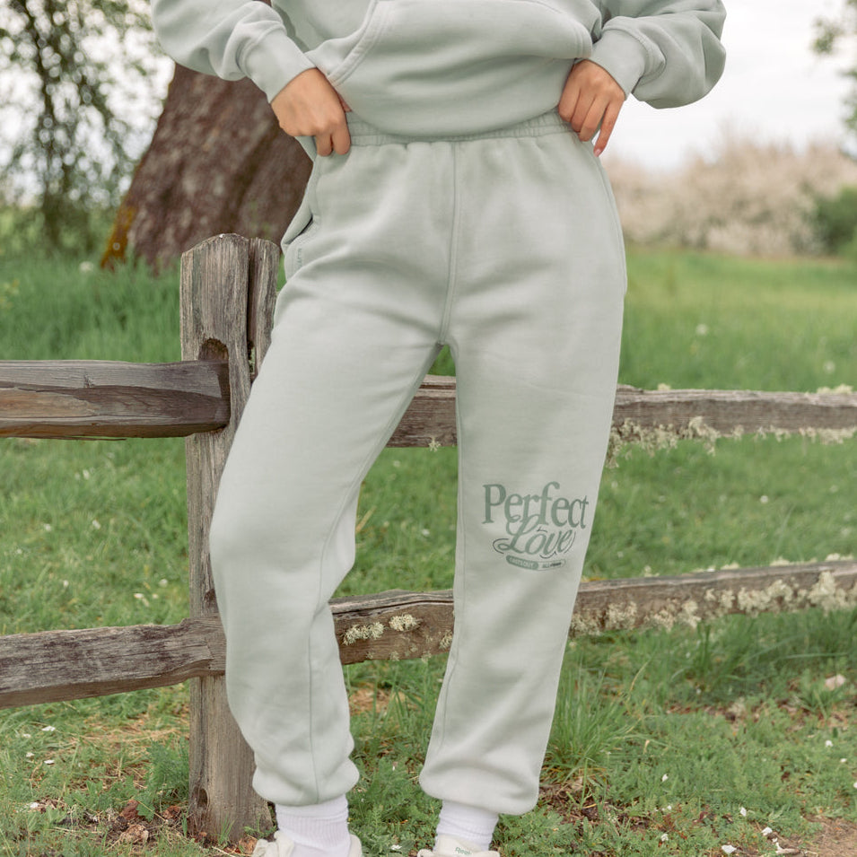 Person wearing a light gray 'Perfect Life' tracksuit in an outdoor setting.